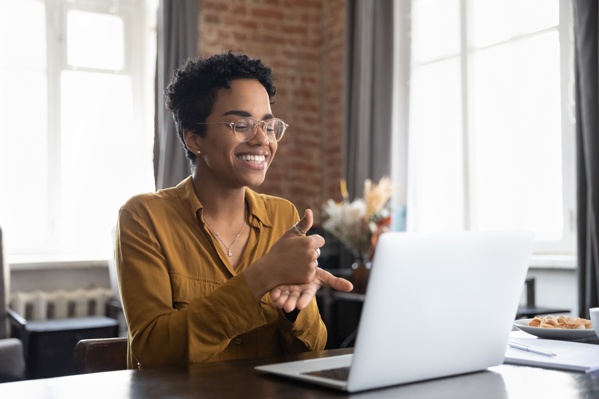 Smiling African American therapist in glasses talking on video call